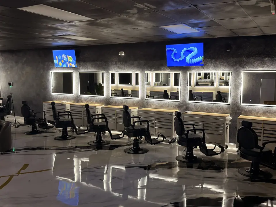 Barbershop floor with backlit mirrors, black barber chairs and marbled floor