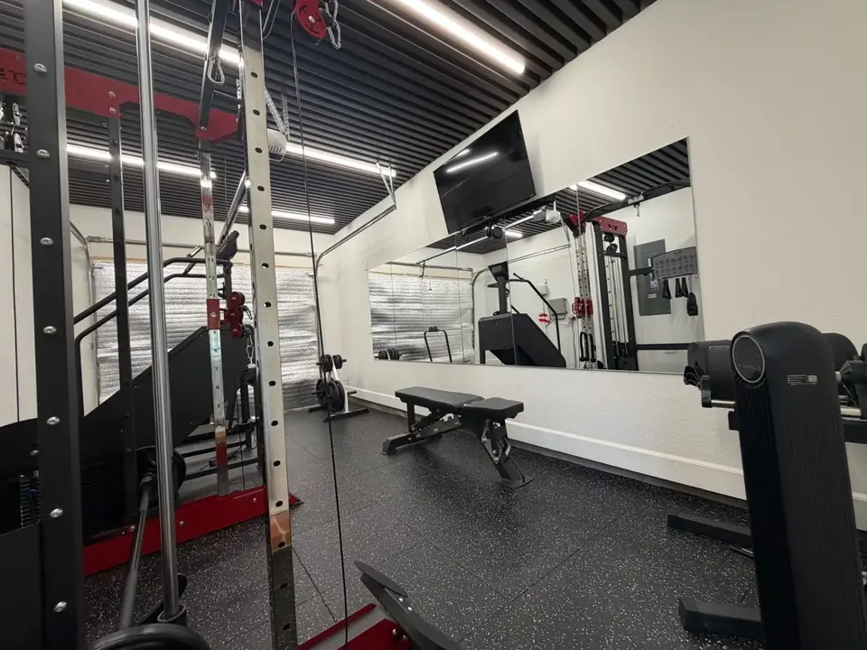Home gym with rubber floor, mirror wall and strength equipment